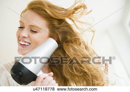Stock Photo - Woman blow drying hair. Fotosearch
