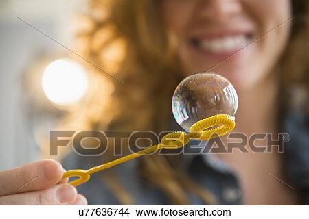 Picture - Woman blowing bubbles. Fotosearch