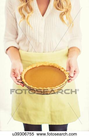 Stock Photography - Woman holding pumpkin pie. Fotosearch