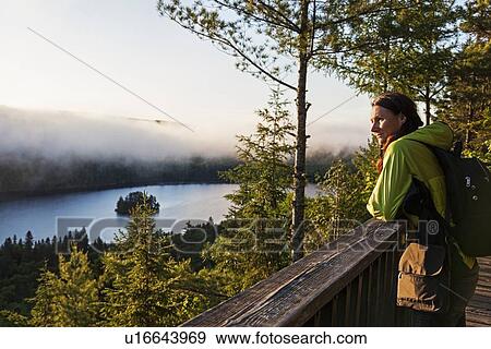 Stock Photo - Woman looking at view from observation point. Fotosearch