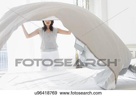 Woman making bed View Large Photo Image Stock Photo - Woman making bed. Fotosearch