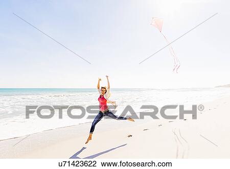 Woman on beach with kite View Large Photo Image Stock Image - Woman on beach with kite. Fotosearch