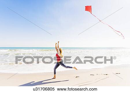 Woman on beach with kite View Large Photo Image Stock Photography - Woman on beach with kite. Fotosearch