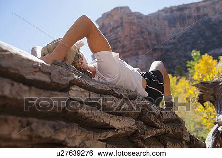 Woman relaxing on rock in mountains View Large Photo Image Stock Photograph - Woman relaxing on rock in mountains. Fotosearch