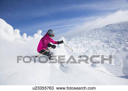 Stock Image - Woman skiing in mountains. Fotosearch