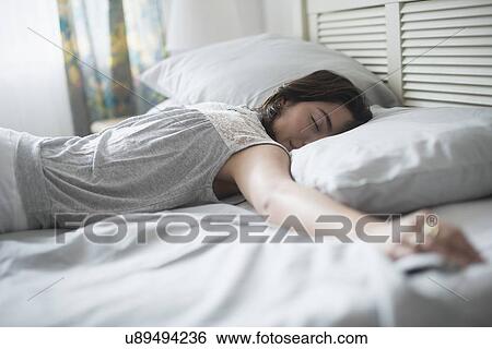 Stock Photograph - Woman sleeping in bed. Fotosearch