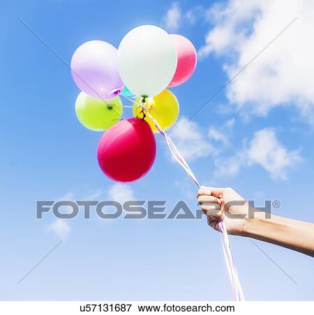 Stock Photo - Young man holding balloons. Fotosearch