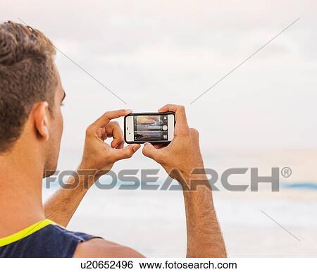 Young man taking photo of sea View Large Photo Image Stock Photograph - Young man taking photo of sea. Fotosearch