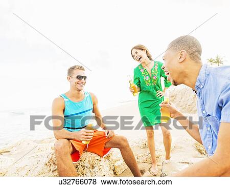 Young people drinking beer on beach View Large Photo Image Stock Photo - Young people drinking beer on beach. Fotosearch