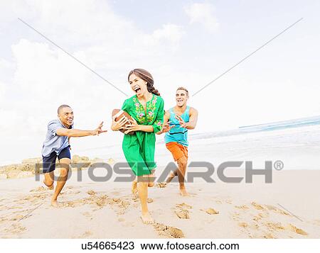 Young people playing with football on beach View Large Photo Image Stock Image - Young people playing with football on beach. Fotosearch