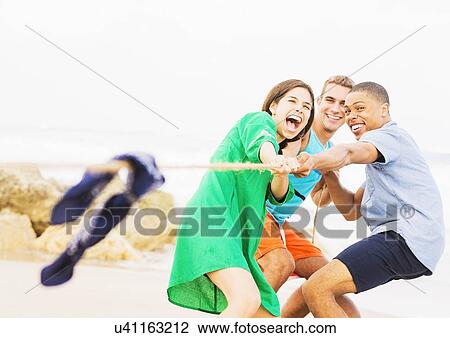 Young people pulling rope on beach View Large Photo Image Stock Image - Young people pulling rope on beach. Fotosearch