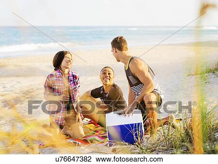 Young people relaxing on beach View Large Photo Image Stock Image - Young people relaxing on beach. Fotosearch