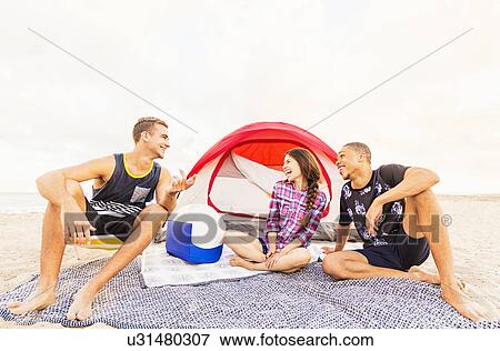 Stock Photo - Young people relaxing on beach. Fotosearch