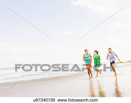 Young people running on beach View Large Photo Image Stock Photo - Young people running on beach. Fotosearch