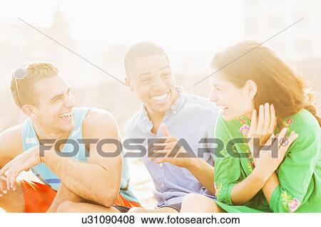 Stock Photo - Young people talking and laughing outdoors. Fotosearch