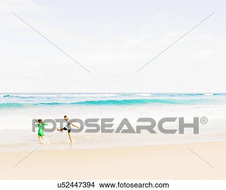 Picture - Young people walking and splashing in water. Fotosearch