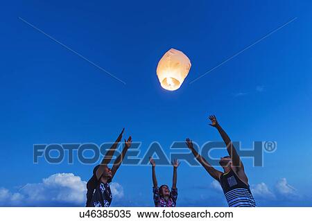 Young people with illuminated lantern at sunset View Large Photo Image Stock Photography - Young people with illuminated lantern at sunset. Fotosearch