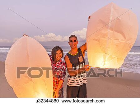 Young people with illuminated lanterns on beach View Large Photo Image Stock Image - Young people with illuminated lanterns on beach. Fotosearch