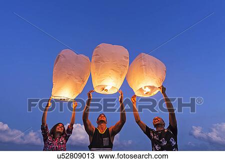 Young people with illuminated lanterns at sunset View Large Photo Image Stock Image - Young people with illuminated lanterns at sunset. Fotosearch