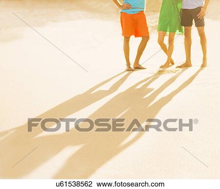 Young people's legs and shadows on beach View Large Photo Image Stock Image - Young people's legs and shadows on beach. Fotosearch