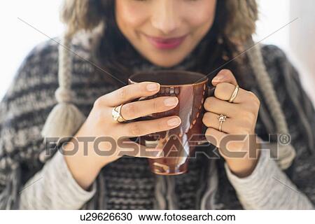 Young woman holding mug with hot drink View Large Photo Image Stock Image - Young woman holding mug with hot drink. Fotosearch