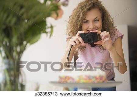 Young woman photographing birthday cake View Large Photo Image Stock Image - Young woman photographing birthday cake. Fotosearch