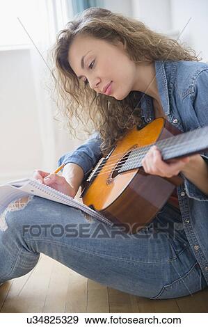Stock Photo - Young woman playing guitar. Fotosearch