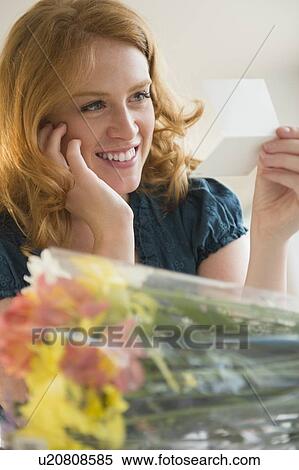 Stock Photography - Young woman reading postcard. Fotosearch