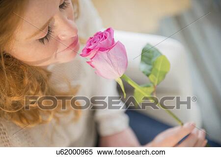 Stock Photography - Young woman smelling rose. Fotosearch