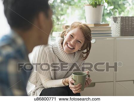 Stock Image - Young woman smiling to friend. Fotosearch