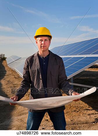 Stock Photograph - Architect with solar panels blueprints. Fotosearch