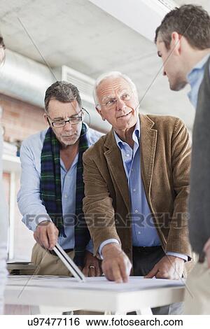 Architects examining blueprints View Large Photo Image Stock Photograph - Architects examining blueprints. Fotosearch