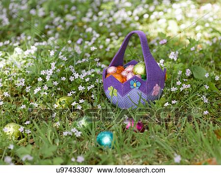 Stock Photo - Basket of Easter eggs in grass. Fotosearch