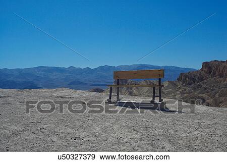 Bench on dirt path in mountains View Large Photo Image Stock Photo - Bench on dirt path in mountains. Fotosearch