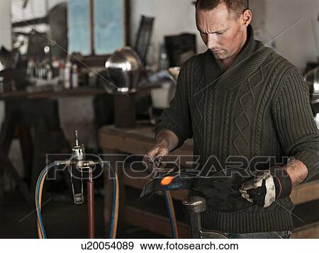 Blacksmith at work in shop View Large Photo Image Stock Photo - Blacksmith at work in shop. Fotosearch