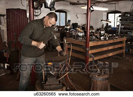 Stock Photography - Blacksmith at work in shop. Fotosearch