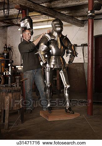 Blacksmith crafting armor in shop View Large Photo Image Stock Photograph - Blacksmith crafting armor in shop. Fotosearch