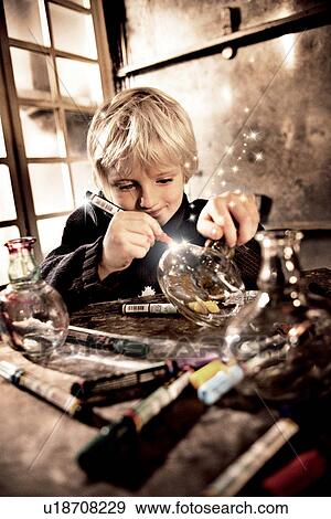 Stock Photo - Boy drawing on glass jar with light. Fotosearch