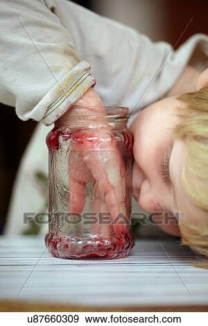 Stock Photo - Boy eating jam from jar. Fotosearch