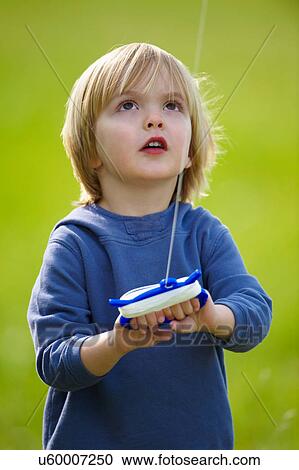 Stock Image - Boy flying kite outdoors. Fotosearch