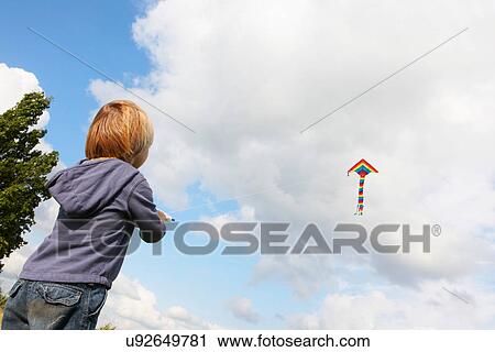 Boy flying kite outdoors View Large Photo Image Stock Image - Boy flying kite outdoors. Fotosearch