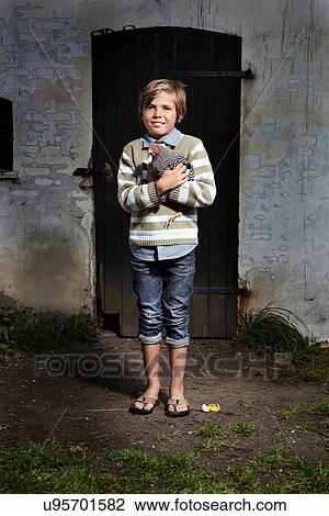 Boy holding chicken outdoors View Large Photo Image Stock Image - Boy holding chicken outdoors. Fotosearch