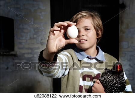 Boy holding egg and chicken outdoors View Large Photo Image Stock Image - Boy holding egg and chicken outdoors. Fotosearch