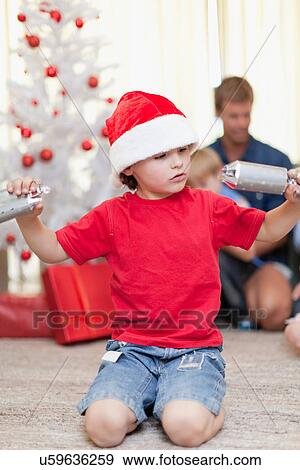 Stock Photo - Boy opening Christmas cracker by himself. Fotosearch