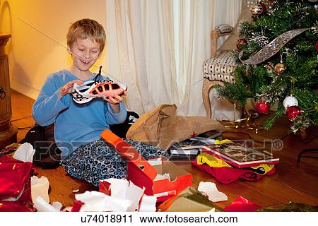 Boy opening Christmas presents View Large Photo Image Stock Image - Boy opening Christmas presents. Fotosearch