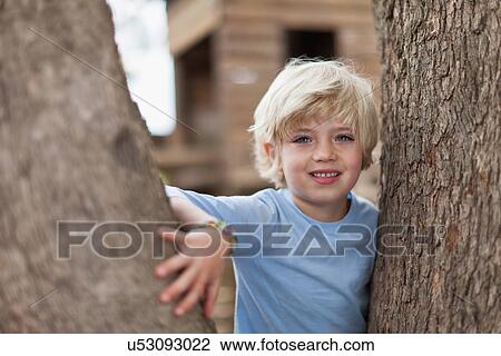 Boy playing in tree outdoors View Large Photo Image Stock Image - Boy playing in tree outdoors. Fotosearch