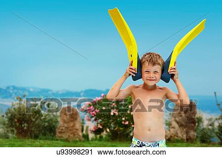 Stock Image - Boy playing with fins outdoors. Fotosearch