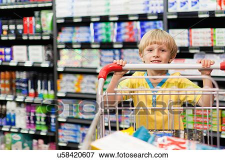 Boy pushing cart in grocery store View Large Photo Image Stock Photo - Boy pushing cart in grocery store. Fotosearch