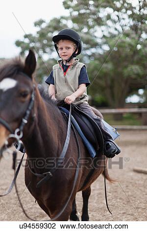 Boy riding horse in yard View Large Photo Image Stock Image - Boy riding horse in yard. Fotosearch