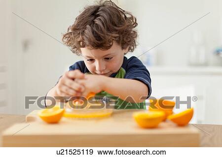 Boy squeezing oranges to make juice View Large Photo Image Stock Photo - Boy squeezing oranges to make juice. Fotosearch